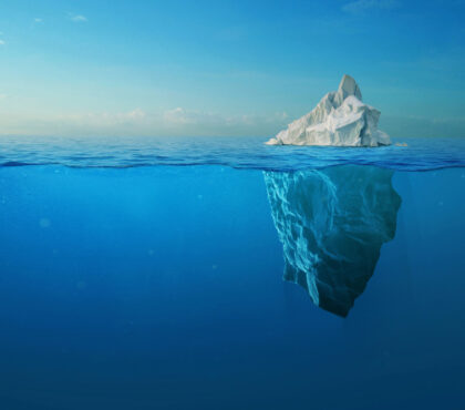 Iceberg en el océano mostrando la pequeña parte visible sobre la superficie y la gran masa oculta bajo el agua, metáfora de la diferencia entre visibilidad e influencia.