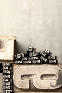 Lead printing types stacked together, evoking the architecture and system behind editorial production.