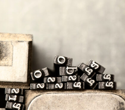 Lead printing types stacked together, evoking the architecture and system behind editorial production.